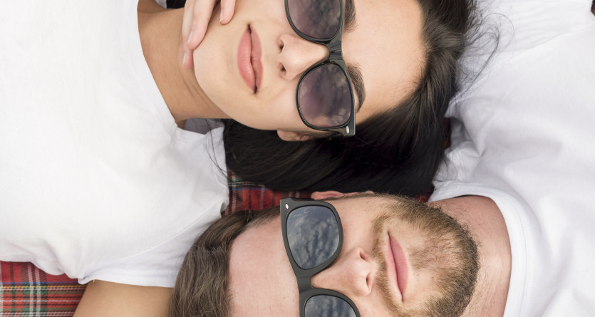 Couple allong&eacute; sur une couverture, lunettes de soleil assorties