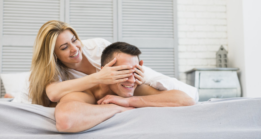 Couple s&rsquo;amusant ensemble sur un lit dans une chambre romantique