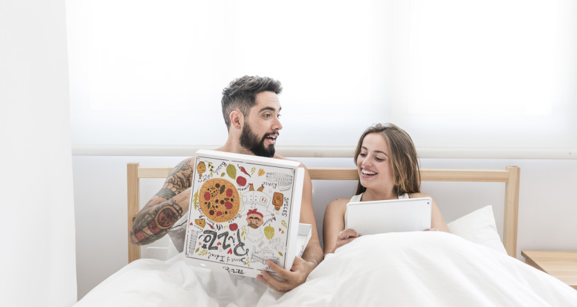 Couple profitant d'un petit-d&eacute;jeuner au lit dans une Love Room
