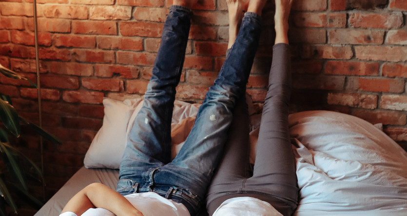 Couple d&eacute;tendu dans une Love Room avec un mur en briques, ambiance industrielle