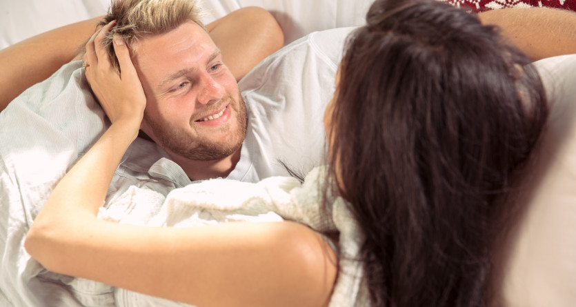 Couple partageant un moment de tendresse au r&eacute;veil dans une chambre avec jacuzzi privatif