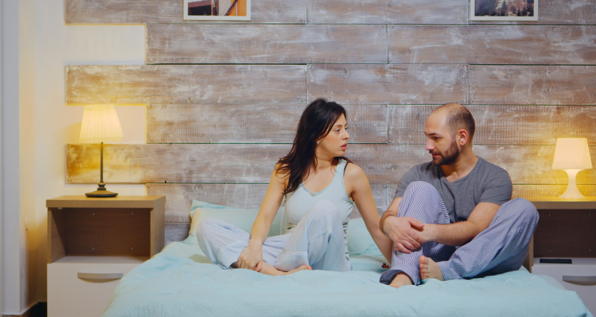 Couple en pleine conversation dans une chambre &agrave; th&egrave;me intime