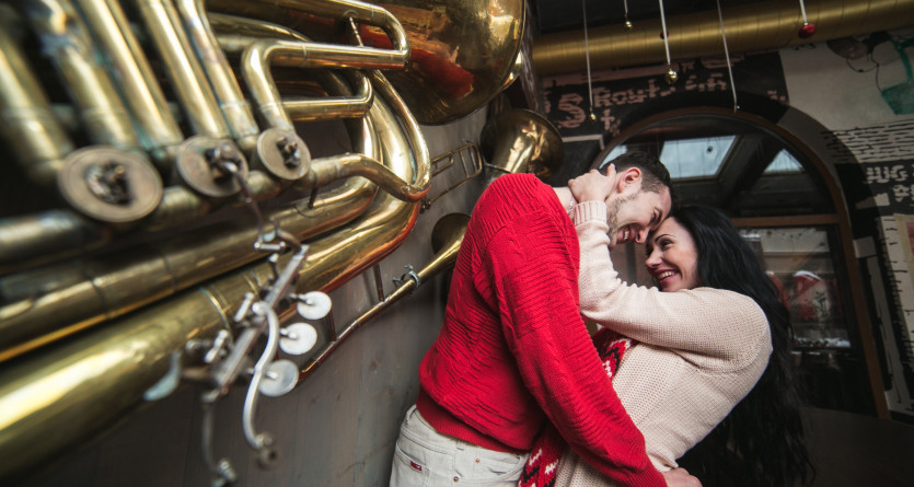 Couple enlac&eacute; dans une ambiance chaleureuse avec un d&eacute;cor de cuivres et instruments musicaux