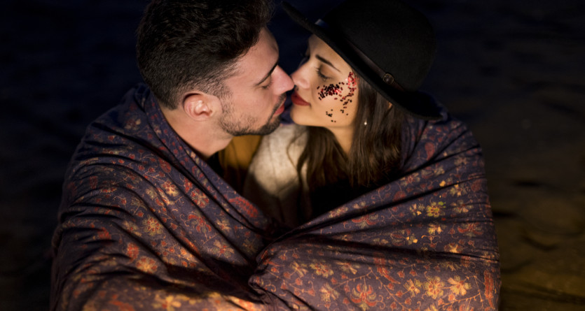 Couple romantique sous une couverture dans une ambiance intime