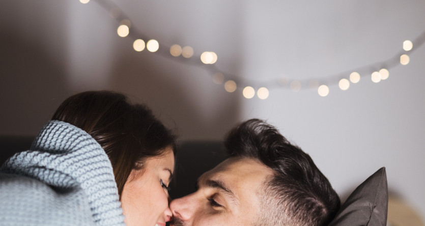 Couple en train de partager un moment romantique dans une chambre &agrave; la d&eacute;coration intime et cosy