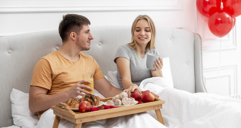 Couple savourant un petit-d&eacute;jeuner au lit, id&eacute;al pour une escapade romantique