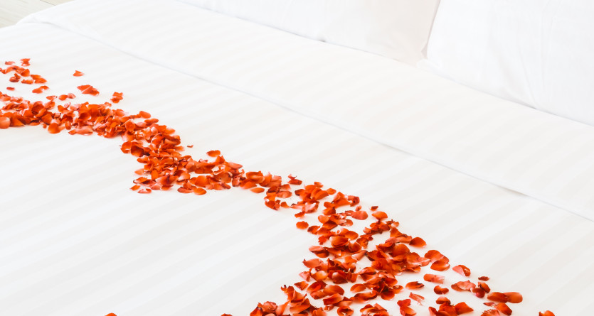 Lit avec des p&eacute;tales de rose formant un c&oelig;ur, id&eacute;al pour une Love Room romantique